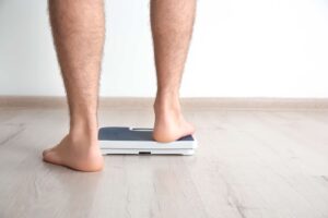 man stepping on scales