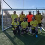 7 men in football kit posing for team picture
